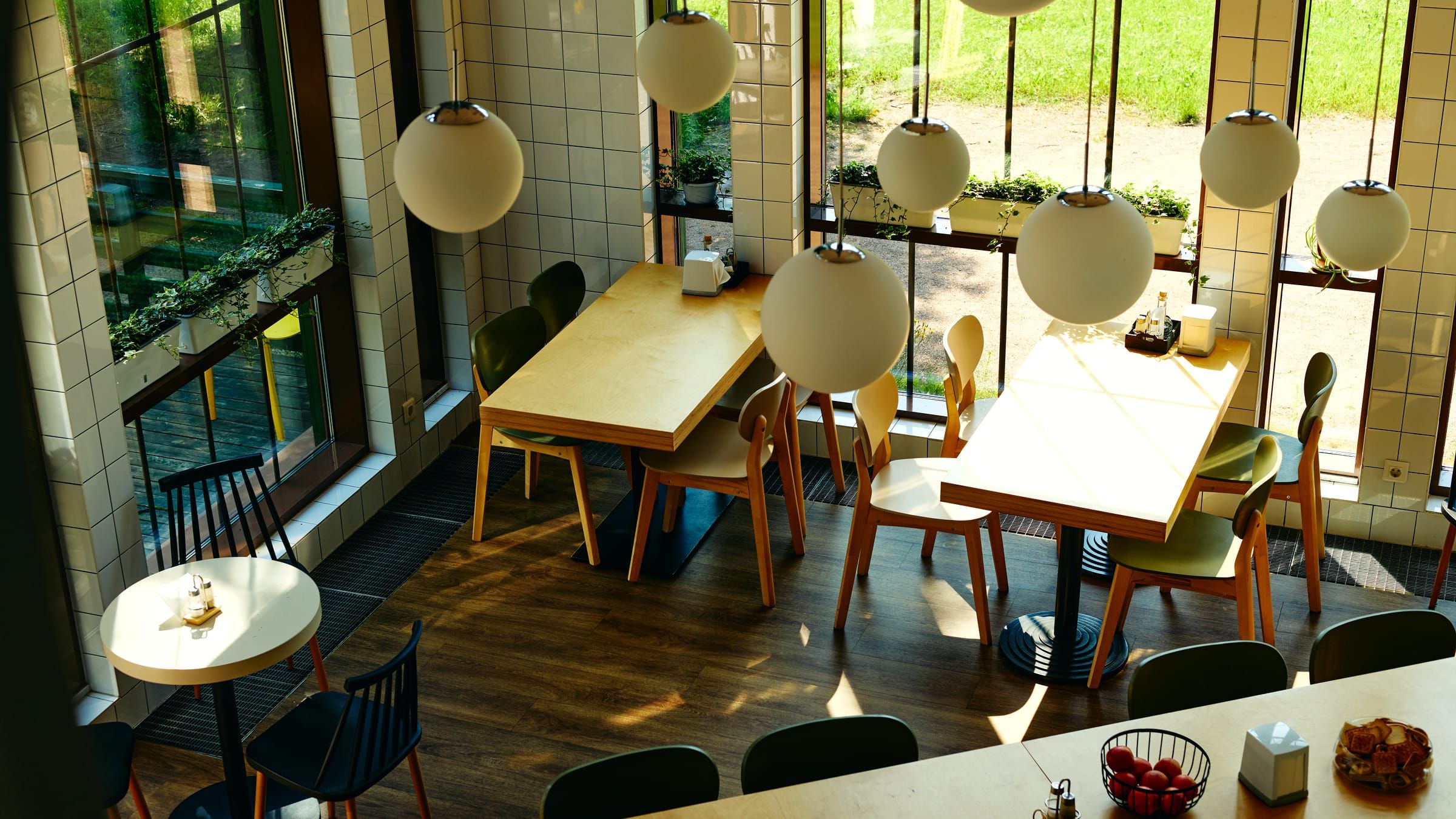 An empty café interior with sunlight streaming across wooden tables